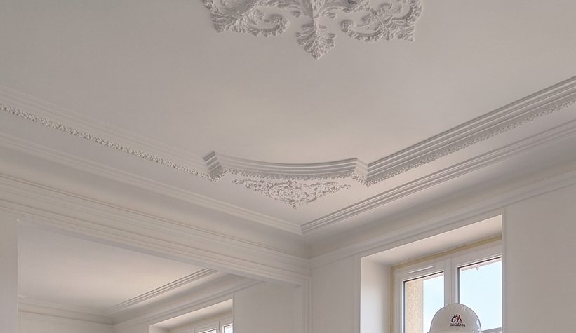 Plafond d'appartement lyonnais ancien : rosace, corniche et moulures après remise en peinture.