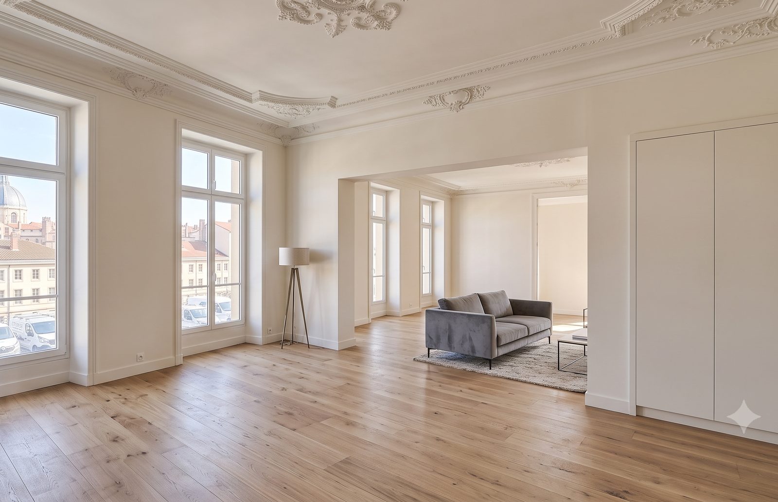 Le même séjour après rénovation : murs et plafond repeints, moulures restaurées, parquet chêne posé.